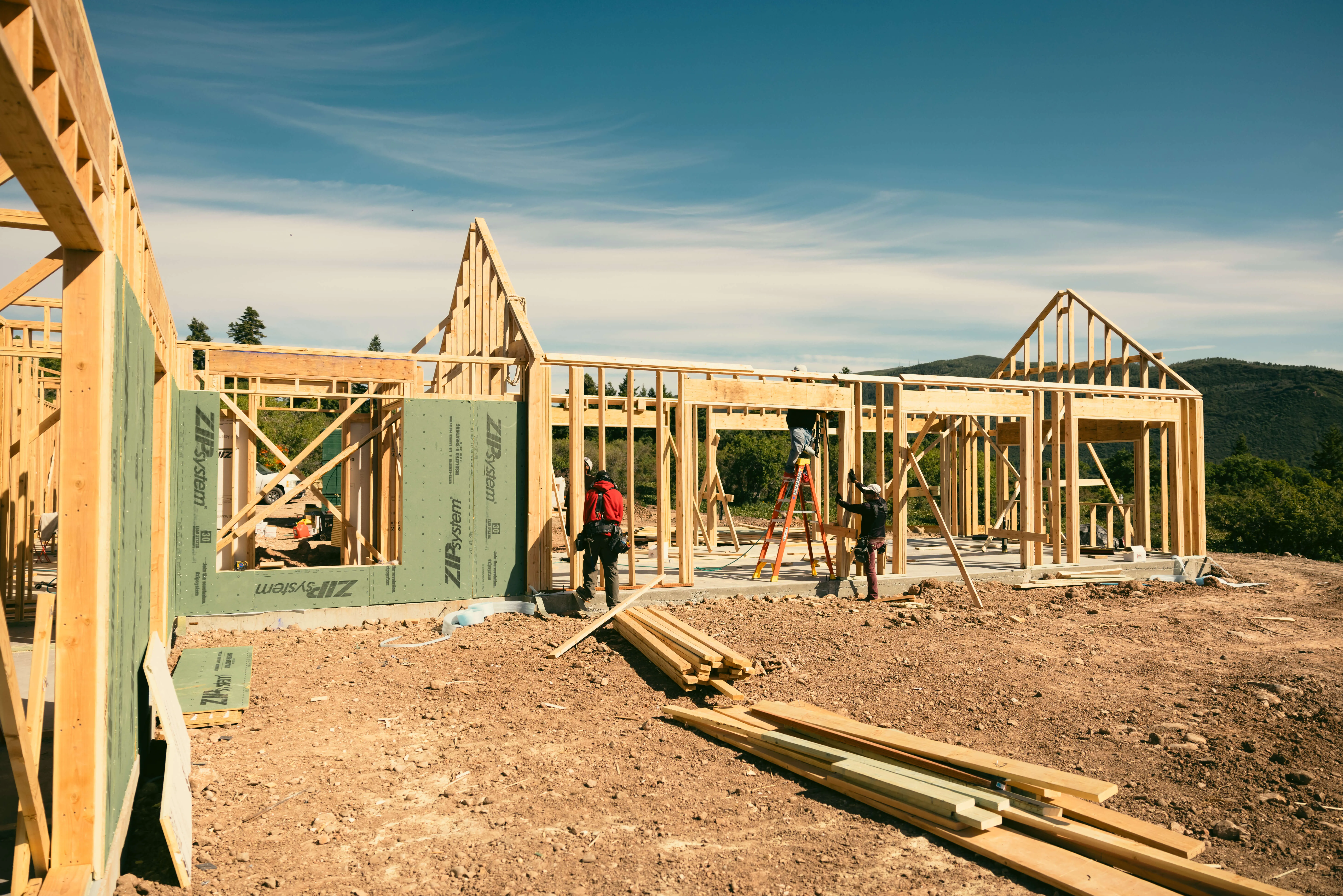 Custom home framing on a Utah hillside site by Bell Mountain Builders.
