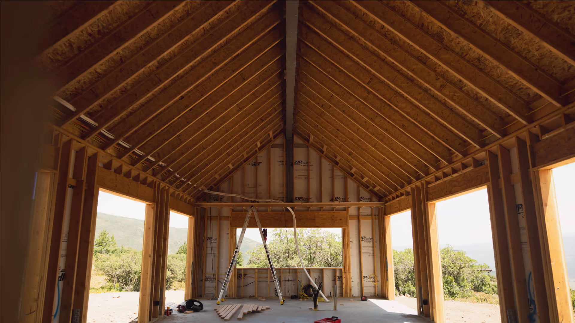 Custom home under construction with exposed framing and vaulted ceiling.
